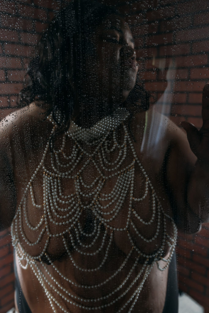 Celebrate self love with boudoir. woman wearing pearls in a shower scene